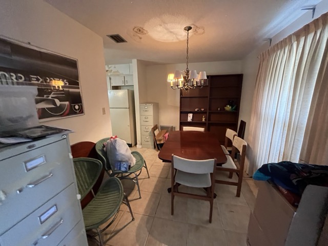 Dining area before - cluttered, dated tile, old fixtures